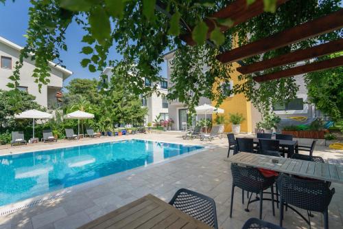 a swimming pool with chairs and a table next to a building at WEST HOUSE EXCLUSIVE HOTEL in Göcek