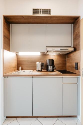 a kitchen with white cabinets and a sink at Appartementhaus Absmeier in Bad Füssing