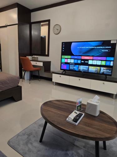 a living room with a coffee table and a large tv at ARMO Nimman in Chiang Mai