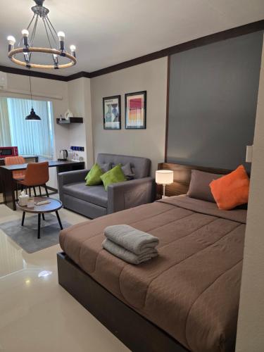 a bedroom with a bed and a living room at ARMO Nimman in Chiang Mai