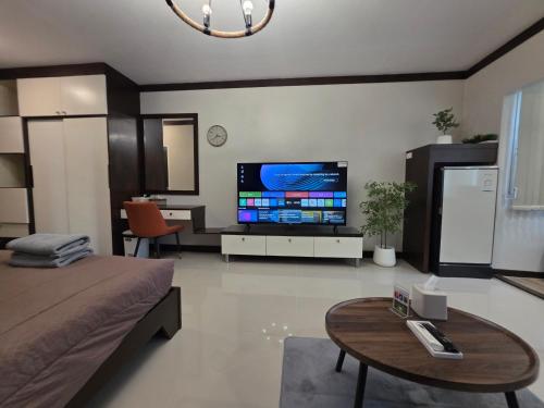 a living room with a large screen tv in a room at ARMO Nimman in Chiang Mai