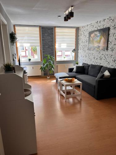 a living room with a black couch and a table at Ferienwohnung auf dem Löperhof in der Altstadt in Halberstadt