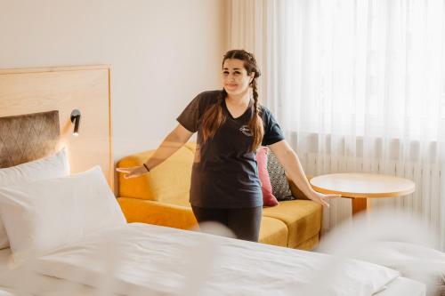 a woman is standing in a hotel room at Appartementhaus Absmeier in Bad Füssing