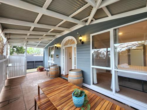 a porch with a wooden bench on a patio at Westend House Healesville in Healesville