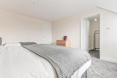 a white bedroom with a bed and a closet at Modern 4-Bed, Parking, Pool Table, Sleeps 11 in Bescot