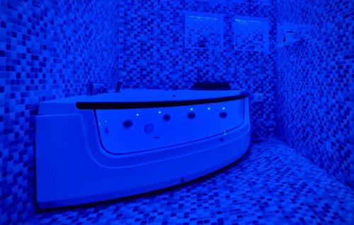 a bathroom with a bath tub in a blue light at Grand Berkshire Signature Hotel operated by Berkshire Hotels & Resorts UK in Islamabad