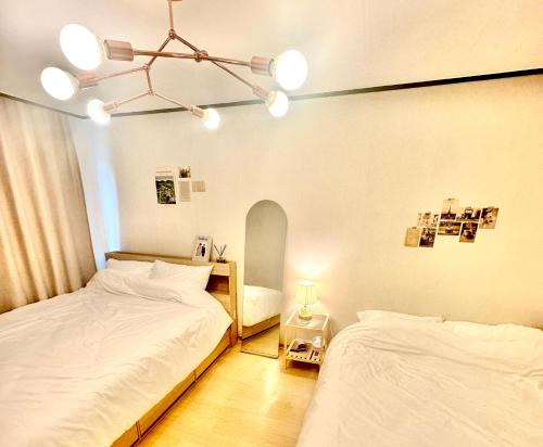 a bedroom with two beds and a chandelier at Konkuk-SeongSu Goznuk Stay in Seoul