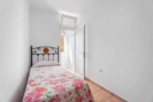 1 dormitorio con 1 cama con manta de flores en Casa Amanecer Atlántico 2 Izquierda, en Playa de San Juan