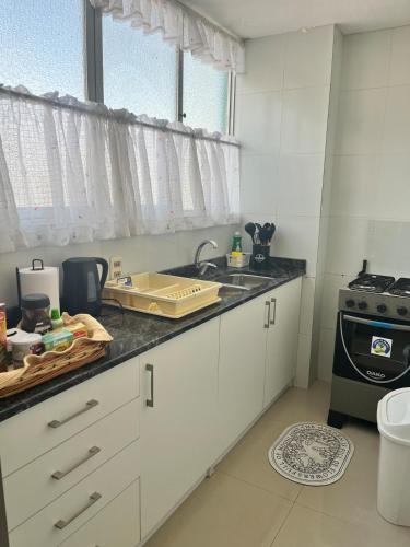 a kitchen with white cabinets and a sink and a stove at Modern, downtown and sunny! in La Paz
