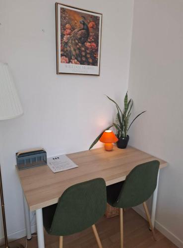 a wooden desk with two chairs and a lamp on it at Apple Inn in Warsaw