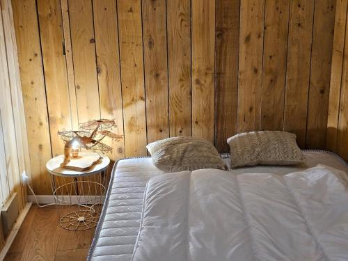 a bed in a room with a wooden wall at Le Carnot, appartement au centre de Roanne in Roanne