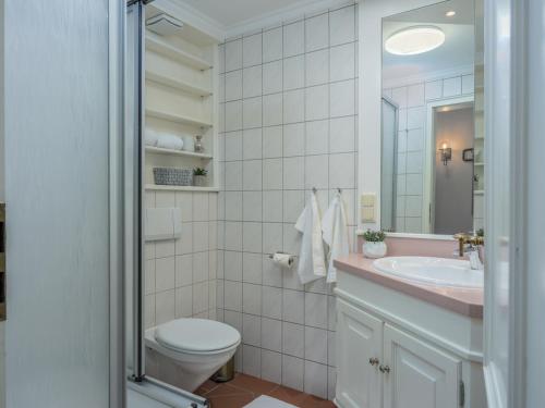 un baño con inodoro y lavabo en Beach Bungalow Sylt 2, en Dikjendeel