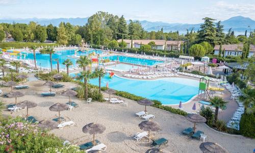 an aerial view of a resort swimming pool with umbrellas at Estivo mobile homes on Camping Bella Italia in Peschiera del Garda