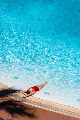 a woman laying in a swimming pool at Palmin Hotel in Kusadası