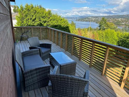 a deck with wicker chairs and tables on a balcony at Cozy house with a sea view in Knarrvika