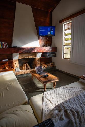 ein Wohnzimmer mit Sofa und Kamin in der Unterkunft White cabin - Casa de Campo em Gonçalves - MG in Gonçalves