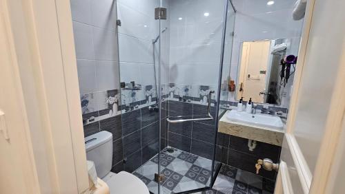 a bathroom with a shower and a toilet and a sink at ADRI Hotel in Phu Quoc