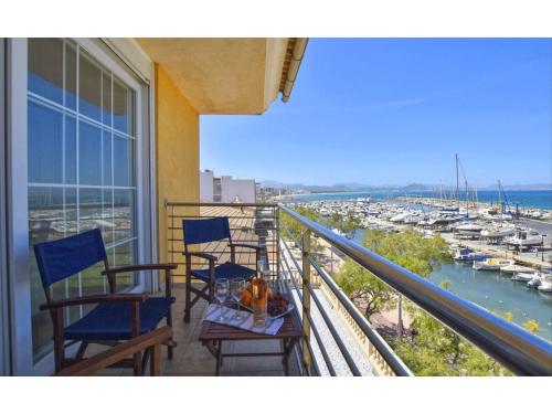 a balcony with chairs and a table with a view of a harbor at Harborfront Escape in Mallorca in Can Picafort