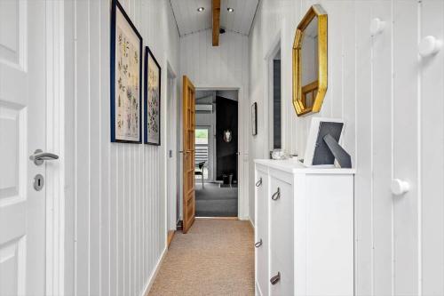 a hallway with white walls and a door with a mirror at LN901-Hjorring-Vadehavsvej-27 in Hjørring
