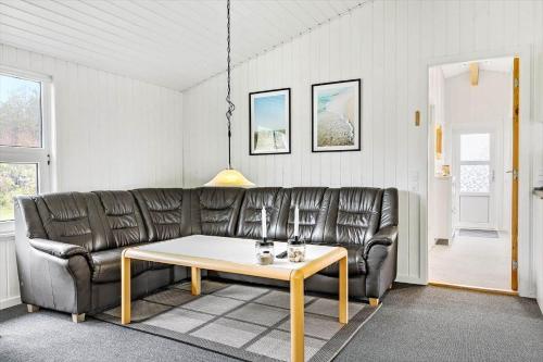 a living room with a leather couch and a table at LN901-Hjorring-Vadehavsvej-27 in Hjørring