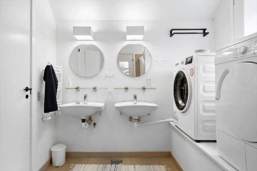a white bathroom with two sinks and a washing machine at LN1913-Hjorring-Rubjergvej-11 in Hjørring
