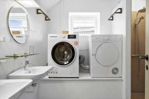 a bathroom with a washing machine and a sink at LN1913-Hjorring-Rubjergvej-11 in Hjørring