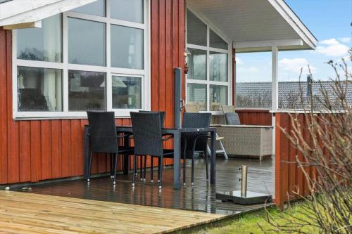 a house with a table and chairs on a deck at LN1971-Lonstrup-Kirkedalsvej-7 in Lønstrup
