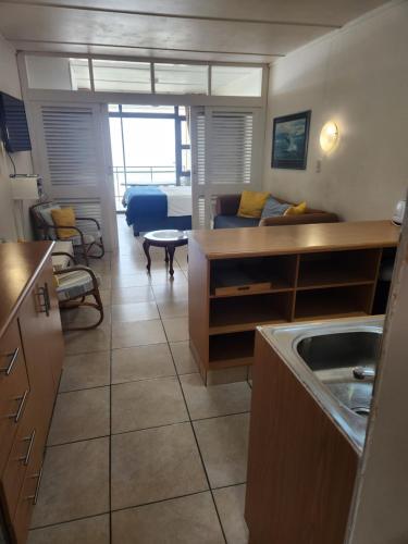 a kitchen and living room with a couch and a table at Driftsands Sea View Flats in Uvongo Beach