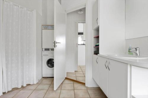 een witte badkamer met een wasmachine en een wastafel bij LN1906-Hjorring-Under-Bjergene-5 in Hjørring