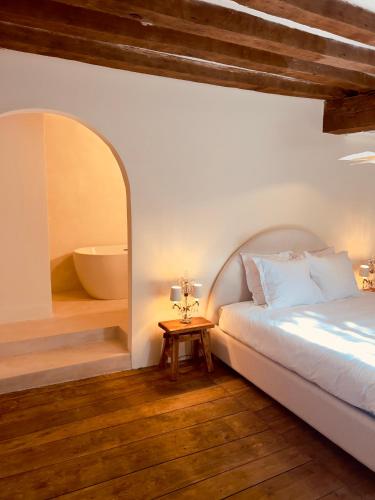ein Schlafzimmer mit Bett und ein Badezimmer mit Badewanne in der Unterkunft Maison G.H. in Champniers-et-Reilhac