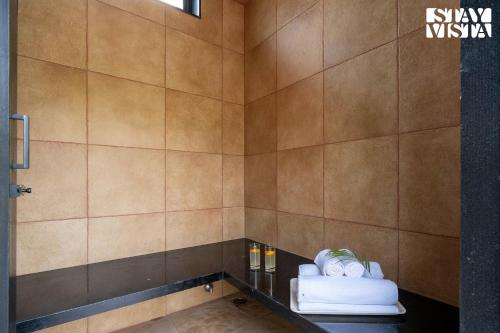 a bathroom with a shower with a black counter at StayVista at The Amaryllis with Heated Pool & Projector Set-Up in Karjat
