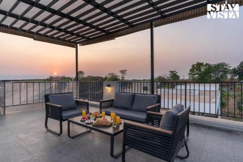 a patio with two chairs and a table at StayVista at The Amaryllis with Heated Pool & Projector Set-Up in Karjat