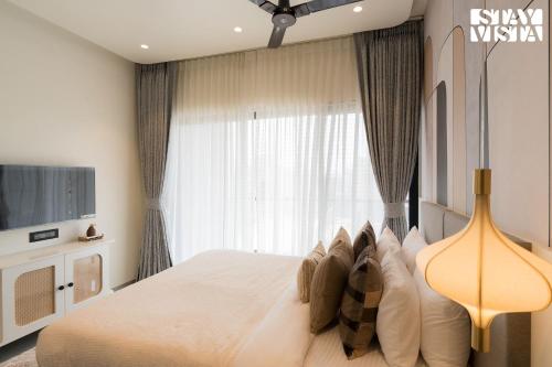 a bedroom with a large bed and a television at StayVista at The Amaryllis with Heated Pool & Projector Set-Up in Karjat