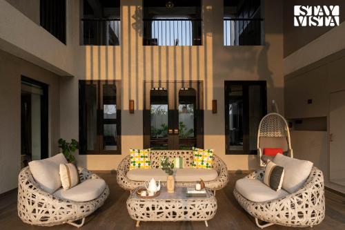 a lobby with two wicker chairs and a table at StayVista at The Amaryllis with Heated Pool & Projector Set-Up in Karjat