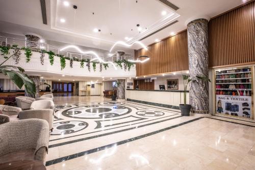 a lobby with a large carpet on the floor at Palmin Hotel in Kusadası