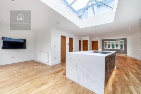 a large white room with a skylight and a kitchen at Modern Luxury 6 Bed Harrow in Hatch End
