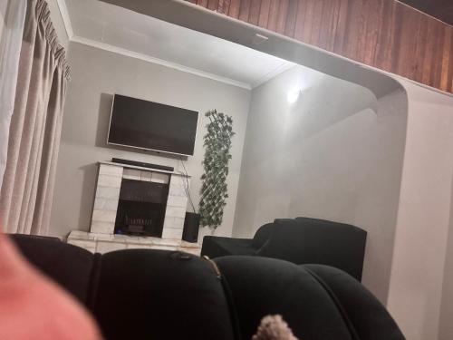 a living room with a tv and a fireplace at FullHouse in Soweto