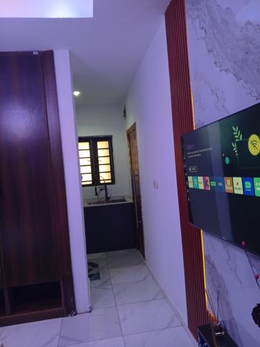 a room with a television and a bathroom with a sink at Peace Dew Apartments in Maiyegun
