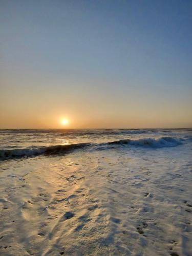 a beach with the sun rising over the ocean at Home in Paradise Costa de Lavos in Costa de Lavos