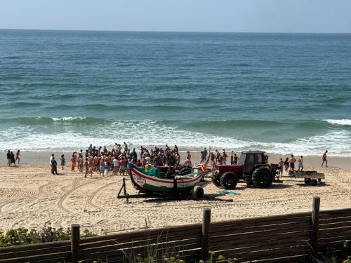 a group of people on a beach with a boat and a tractor at Home in Paradise Costa de Lavos in Costa de Lavos