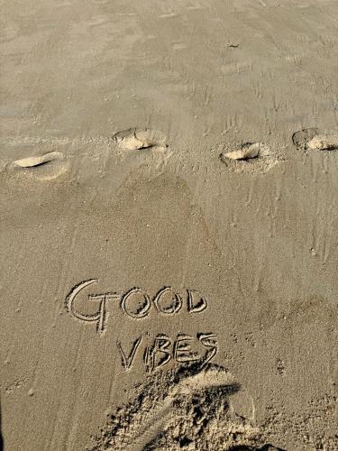 a pair of footprints in the sand with the words good vs less at Home in Paradise Costa de Lavos in Costa de Lavos