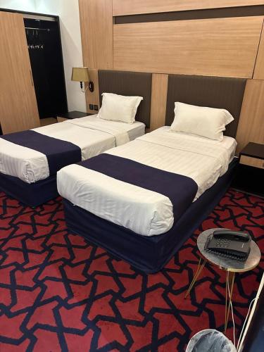 two beds in a room with a carpet at ميرا سويت للشقق المخدومة in Jeddah