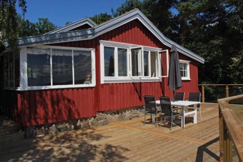 a red house with a table and chairs on a deck at VGO756-Alingsas-Slinkebovaegen-22 in Björkekärr