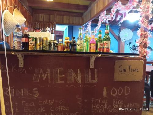 a bar with a bunch of bottles of alcohol at Three Ken Homestay & Cafe in Manado
