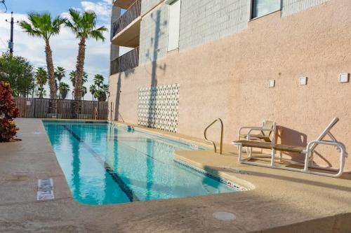 a swimming pool with a bench next to a building at Walk to Beach House in Heart of Entertainment District - Atrium unit 102 in South Padre Island