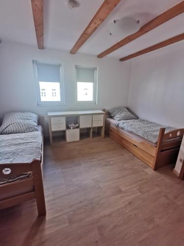 una habitación con dos camas y dos ventanas en Domidyll, en Fulda
