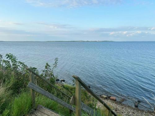 a view of the ocean with a wooden fence at Holiday Home With Fjord Views By Isefjord in Nykøbing Sjælland