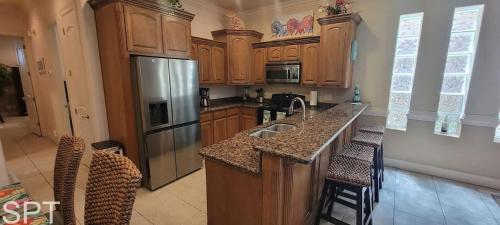 a kitchen with wooden cabinets and a stainless steel refrigerator at Island Time #4 condo in South Padre Island