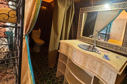 ein Badezimmer mit Waschbecken und Spiegel in der Unterkunft luxury desert night camp in Merzouga