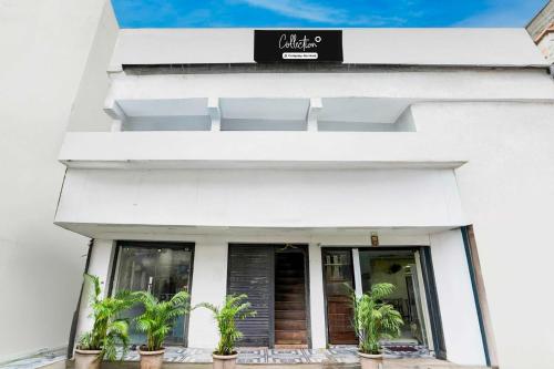 a white building with potted plants in front of it at Collection O Dombivali in Mumbai